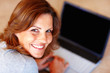 Happy young woman with a laptop at home