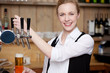 kellnerin zapft bier an der theke