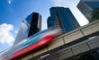 Modern monorail train with office buildings in the background Modern monorail train with office buildings in the background