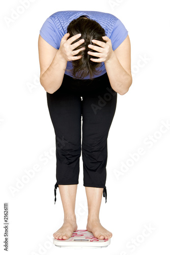Photo: Woman standing on scales. Woman standing on scales.
