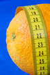 An orange and a measuring tape concepts of healthy diet