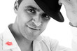 seductive man greeting with his hat and shirt with lipstick mark