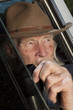 Senior Man With Cowboy Hat Sitting in Vehicle