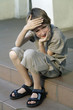 dumpish boy, sitting on stair