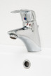 Photo: One chrome faucet in washbowl in bath room on white pile One chrome faucet in washbowl in bath room on white pile