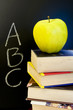 ABC written on blackboard with apple and books