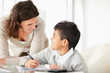 Foto: Middle aged lady helping her son to do homework Middle aged lady helping her son to do homework