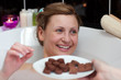 Bright woman eating chocolate while having a bath Bright woman eating chocolate while having a bath