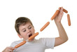 Hungry boy bites sausage