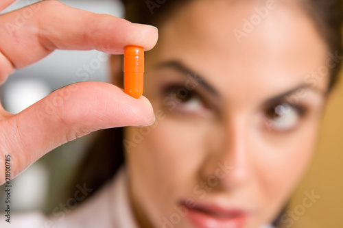 Photo: Woman holding a pill Woman holding a pill