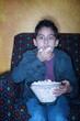 Hispanic boy  with popcorn watching television