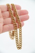 Dicke Goldkette in der Hand.