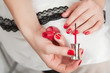 Photo: Woman applying red nail polish Woman applying red nail polish