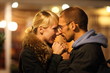 man and woman is cuddling in coldly nightly fall city