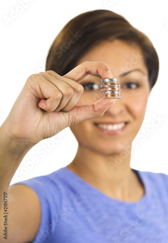 Photo: Young woman holds a stack of coins between her fingers. Young woman holds a stack of coins between her fingers.