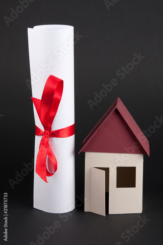 Photo: House model with sealed document House model with sealed document
