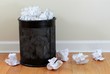 Papierkorb auf Boden vor Wand