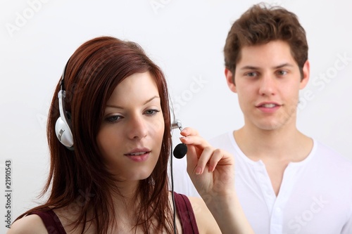 Photo: young woman with headset (with a man) young woman with headset (with a man)
