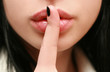 secret. beautiful girl with his finger near the lips secret. beautiful girl with his finger near the lips