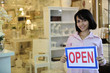 Photo: small business owner: woman holding an open sign small business owner: woman holding an open sign