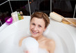 Smiling woman playing in a bubble bath Smiling woman playing in a bubble bath