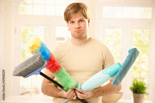 Photo: Upset guy with cleaning tools Upset guy with cleaning tools