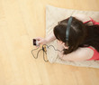 Brunette woman listening music lying down on the floor Brunette woman listening music lying down on the floor