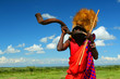Masai warrior playing traditional horn Masai warrior playing traditional horn