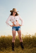 Beautiful slavonic girl in cowboy clothes pose in wheat field