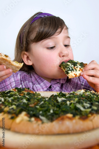 Foto: Mädchen schlingt Pizza hinunter Mädchen schlingt Pizza hinunter