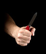 Knife in hand isolated on black background