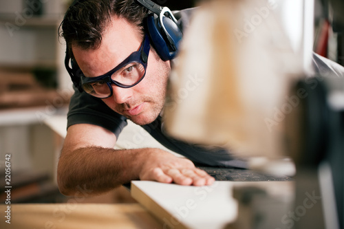 Photo: Carpenter using electric saw Carpenter using electric saw