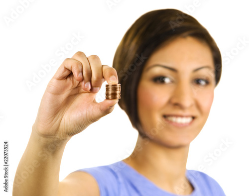 Photo: Young woman squeezes a stack of pennies. Young woman squeezes a stack of pennies.