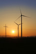 Windrad und Strommast im Sonnenuntergang