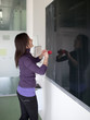 pretty young college student erasing the chalkboard/blackboard i