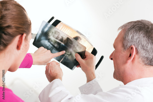 Photo: Dentist explaining x-ray to patient Dentist explaining x-ray to patient