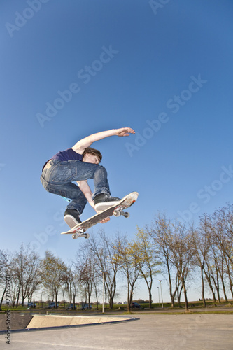 Photo: boy with skate board is going airborne boy with skate board is going airborne