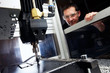 man watching CNC machine in progress man watching CNC machine in progress