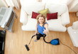 High angle of a cheerful woman vacuuming High angle of a cheerful woman vacuuming