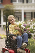 Young boy in wheelchair with flowers outdoors