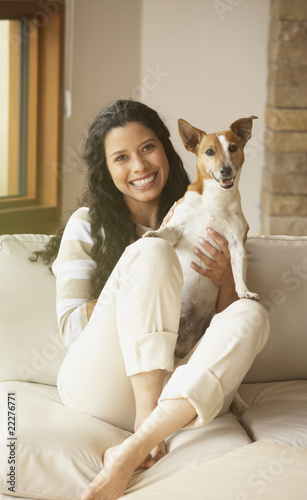 Foto: Hispanic woman sitting on sofa with dog Hispanic woman sitting on sofa with dog