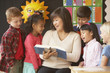 Asian female teacher reading to students