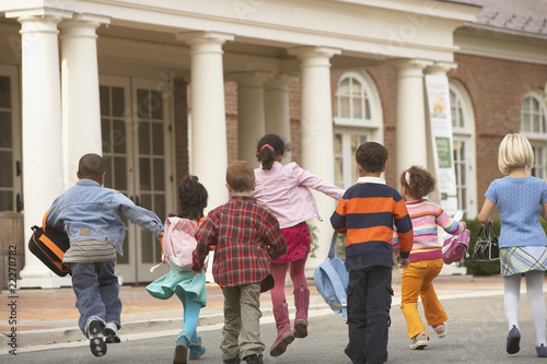 Photo: Multi-ethnic students running toward building Multi-ethnic students running toward building