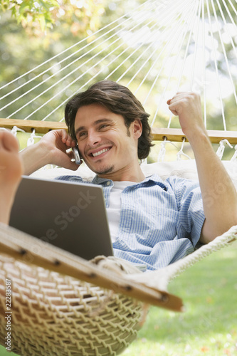 Foto: Man in hammock talking on cell phone Man in hammock talking on cell phone