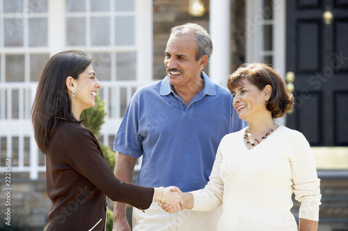 Photo: Senior Hispanic couple shaking hands with realtor Senior Hispanic couple shaking hands with realtor