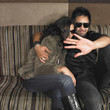 Multi-ethnic couple with hand up on sofa