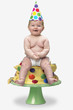 Baby sitting on birthday cake