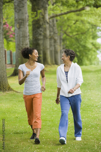 Photo: African American mother and adult daughter walking in park African American mother and adult daughter walking in park