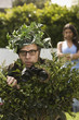 Man using bush as camouflage