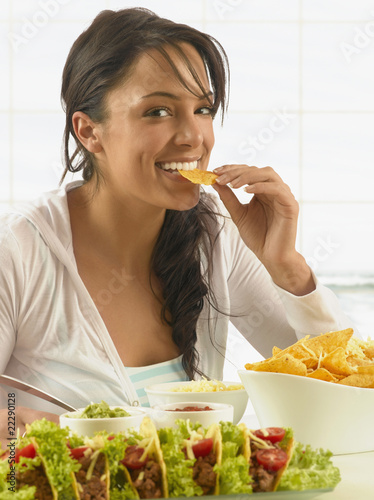 Photo: Hispanic woman eating chips Hispanic woman eating chips